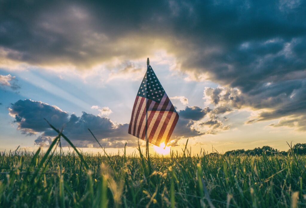 American Flag In Grassy Field